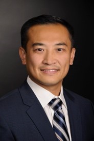 A person in a suit and tie Description automatically generated with medium confidence